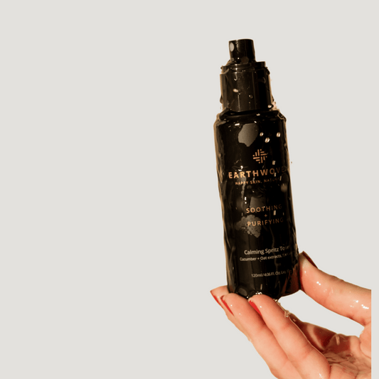 Earthwoven Calming Spritz Toner bottle held under running water, showcasing its hydrating and soothing properties