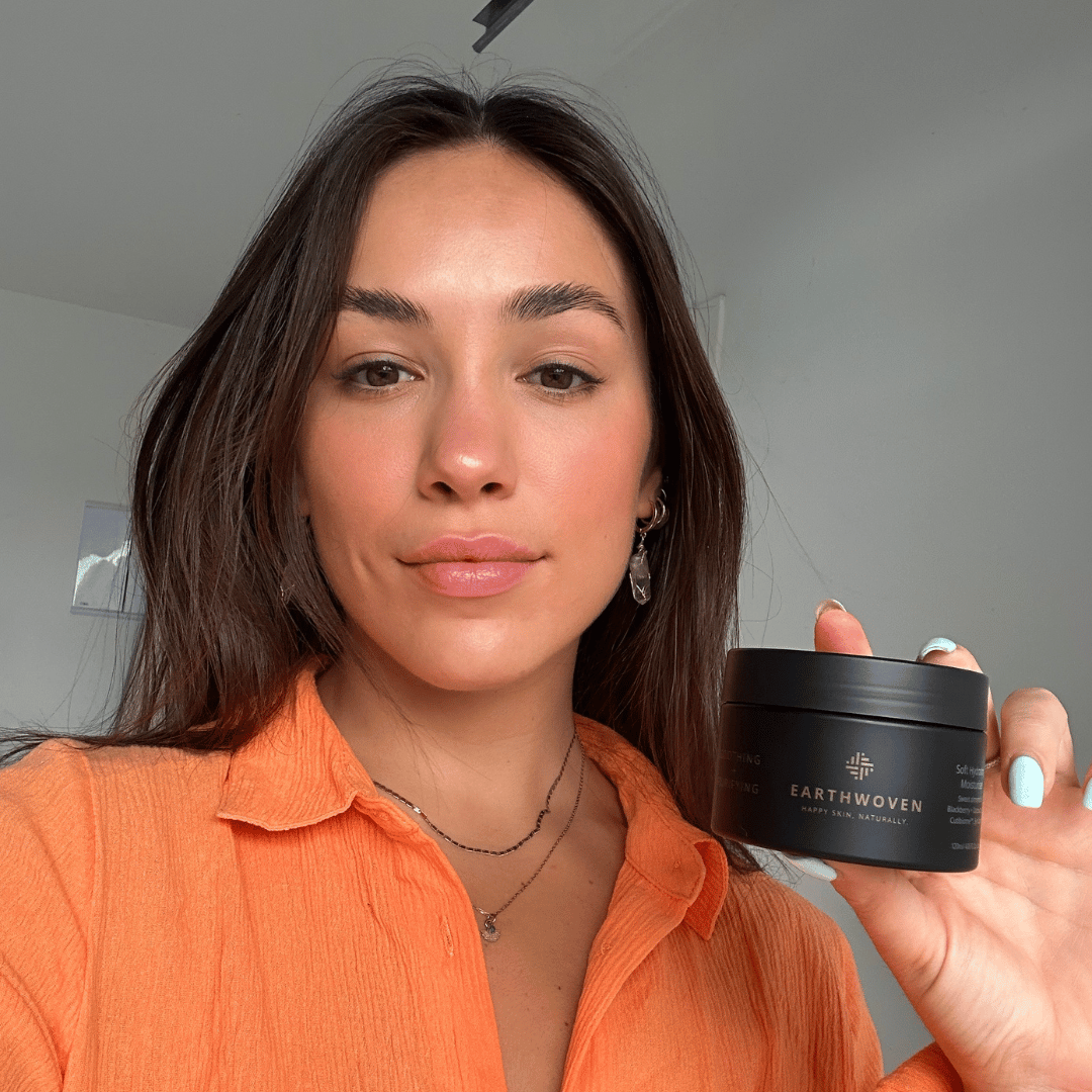 Soft Hydrating Moisturizer held by a woman, showcasing its lightweight hydration for acne, eczema, and sensitive skin.